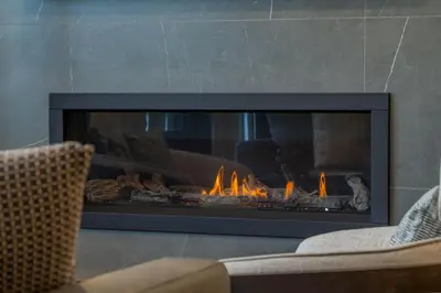 a fireplace with flames in a living room at Brand New Canmore Condo by Canadian Rockies Vacation Rentals in Canmore