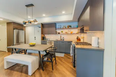 a kitchen with a table and some chairs and a counter at Brand New Canmore Condo by Canadian Rockies Vacation Rentals in Canmore
