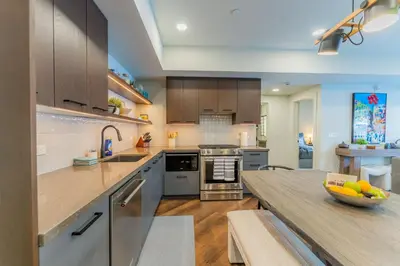 a large kitchen with a counter top and a bowl of fruit at Brand New Canmore Condo by Canadian Rockies Vacation Rentals in Canmore