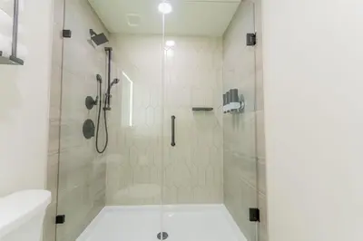 a bathroom with a shower with a glass door at Brand New Canmore Condo by Canadian Rockies Vacation Rentals in Canmore