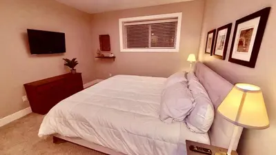 a bedroom with a white bed and a television at Fields & Fences Suite in Maple Ridge District Municipality