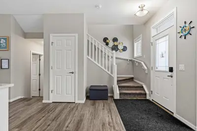 a hallway with a staircase and a white door at Family 3BR Suite w Kid's Play Tent, FREE Banff Pass, Netflix! in Calgary