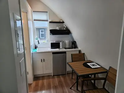 a small kitchen with a table and a sink and a stove at Pet Friendly cozy cabin getaway with Kitchenette and Private Bath in Port Renfrew
