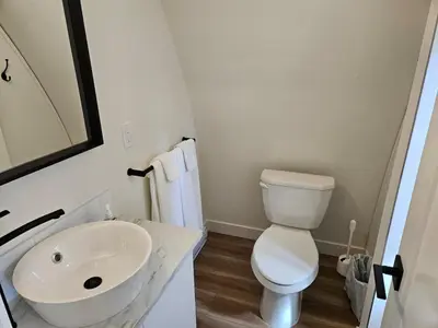 a white bathroom with a sink and a toilet at Pet Friendly cozy cabin getaway with Kitchenette and Private Bath in Port Renfrew