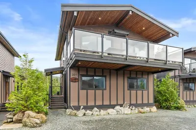 a house with a glass facade with a balcony at Wild Beauty - Oceanview - Pet Friendly - sleep 2 in Port Renfrew