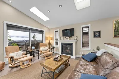 a living room with a leather couch and a fireplace at Wild Beauty - Oceanview - Pet Friendly - sleep 2 in Port Renfrew