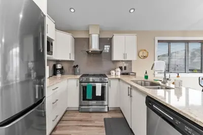 a kitchen with white cabinets and a stove top oven at Wild Beauty - Oceanview - Pet Friendly - sleep 2 in Port Renfrew
