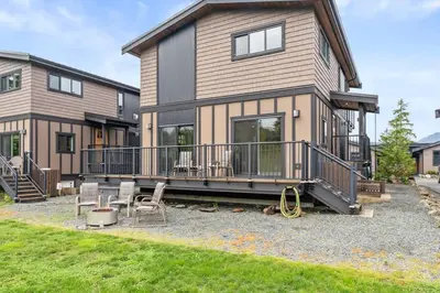 a house with a deck and chairs in front of it at Wild Beauty - Oceanview - Pet Friendly - sleep 2 in Port Renfrew
