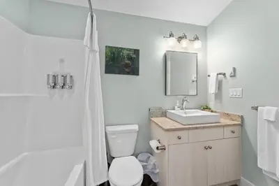 a white bathroom with a toilet and a sink at Wild Beauty - Oceanview - Pet Friendly - sleep 2 in Port Renfrew