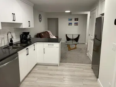a kitchen with white cabinets and a counter top at Modern Comfort in NW Calgary in Calgary