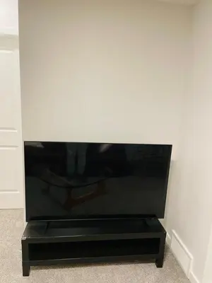 a flat screen tv sitting on a black stand at Modern Comfort in NW Calgary in Calgary