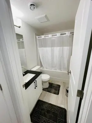 a white bathroom with a toilet and a sink at Modern Comfort in NW Calgary in Calgary