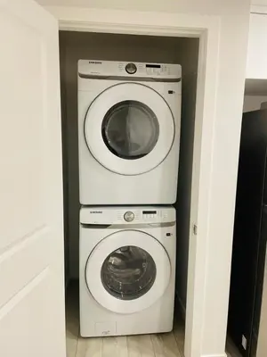 a laundry room with a washer and a washing machine at Modern Comfort in NW Calgary in Calgary