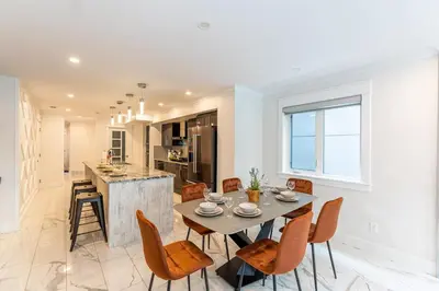 a kitchen and dining room with a table and chairs at Family friendly Lux house Near University Train Hospital in Edmonton