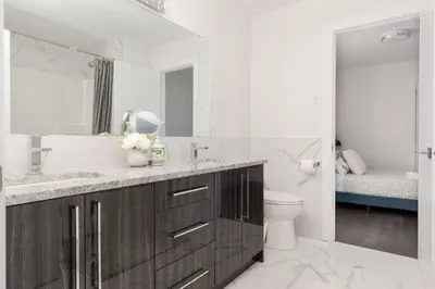 a bathroom with a sink and a toilet and a mirror at Family friendly Lux house Near University Train Hospital in Edmonton