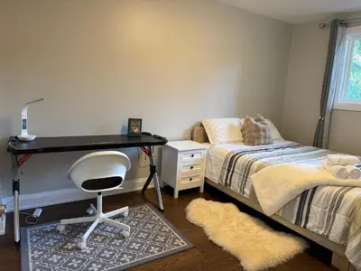a bedroom with a desk and a bed and a chair at Queen bedroom suite with private bathroom and independent entrance in Kelowna