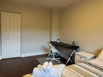 a room with a bedroom with a desk and a bed at Queen bedroom suite with private bathroom and independent entrance in Kelowna