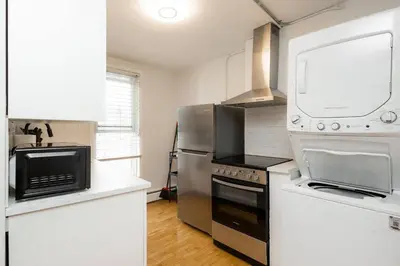 a kitchen with a stove and a refrigerator at Quiet & Walkable - Stampede, BMO, Nightlife & Eats in Calgary