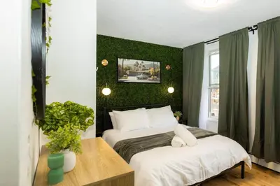 two beds in a room with green walls at Quiet & Walkable - Stampede, BMO, Nightlife & Eats in Calgary