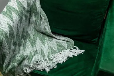 a green couch with a white blanket on it at Quiet & Walkable - Stampede, BMO, Nightlife & Eats in Calgary