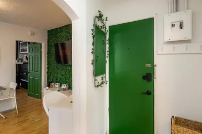 a green door in a living room with a table at Quiet & Walkable - Stampede, BMO, Nightlife & Eats in Calgary