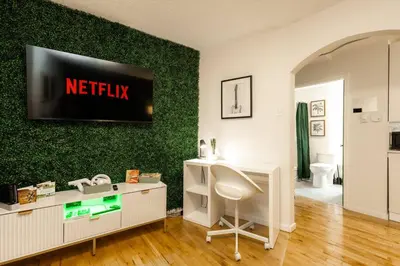a living room with a television on a green wall at Quiet & Walkable - Stampede, BMO, Nightlife & Eats in Calgary