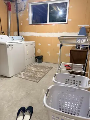 a laundry room with a washing machine and a window at Gans Home - 5 Bedroom Residence in Lloydminster