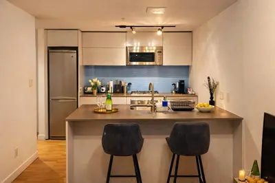 a kitchen with a counter and two bar stools at Pacific Pearl in Vancouver