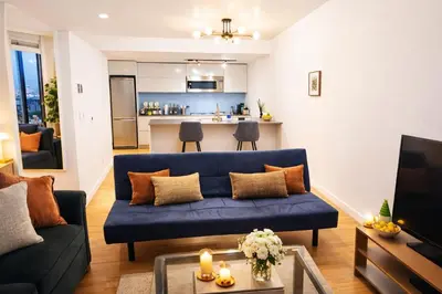 a living room with a blue couch and a kitchen at Pacific Pearl in Vancouver