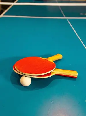 a tennis racket and a ball on a blue court at Family Retreat Hot Tub Banff and Calgary DT Access in Calgary