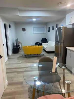a living room with a glass table and a yellow couch at Beautiful one Bedroom Bsmnt suite with sep Entrance in Edmonton