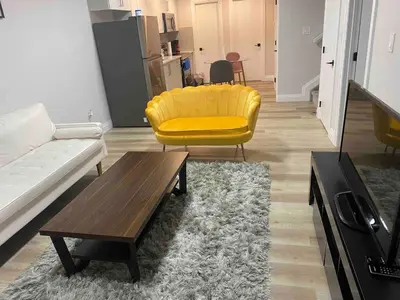 a living room with a yellow couch and a coffee table at Beautiful one Bedroom Bsmnt suite with sep Entrance in Edmonton