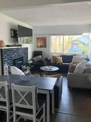 a living room with a couch and a fireplace at Quiet-comfy 4 bedroom house on a tree lined street in Kitsilano in Vancouver