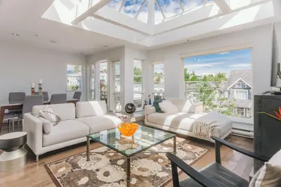 a living room with a white couch and a glass table at Private Penthouse Beside Beach with Rooftop Patio in Vancouver