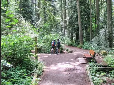 two people standing on a dirt trail in the woods at Dunbar Home in Vancouver