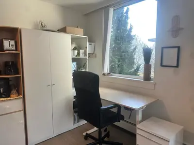 a desk and a chair in a room with a window at Beach House in Vancouver