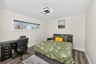 a bedroom with a bed and a desk and a chair at NEW 2BR Near Downtown Calgary - Private Entry - Airport Access - 4412 UP in Calgary