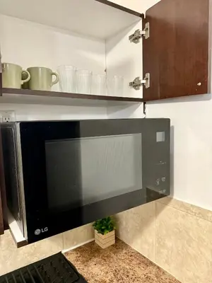 a large black microwave oven in a kitchen at Cozy 1-Bed Basement Suite in Calgary