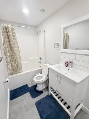 a white bathroom with a toilet and a sink at Private 1BR Suite with Kitchen, Laundry, Parking & 1 Gigabit Internet in Whitehorse