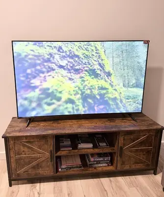 a flat screen tv sitting on top of a wooden entertainment center at Private 1BR Suite with Kitchen, Laundry, Parking & 1 Gigabit Internet in Whitehorse