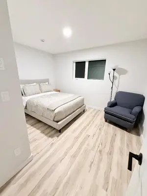 a bedroom with a bed and a couch and a chair at Private 1BR Suite with Kitchen, Laundry, Parking & 1 Gigabit Internet in Whitehorse