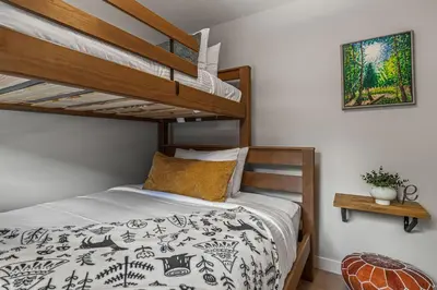 a bedroom with a bunk bed with a ladder at 3BR Canmore Haven w/ BBQ and free parking in Canmore