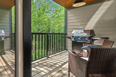a screened in porch with two chairs and a grill at 3BR Canmore Haven w/ BBQ and free parking in Canmore