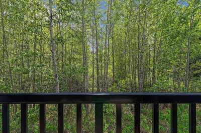a balcony with a view of the woods at 3BR Canmore Haven w/ BBQ and free parking in Canmore