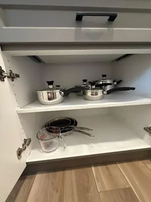 a shelf with pots and pans in a kitchen at Fort Home in Fort Saskatchewan