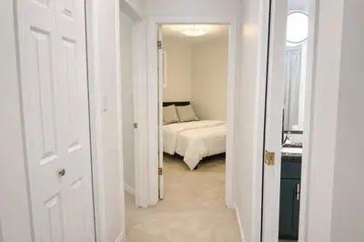 a white bedroom with a bed in a room at 4-Level Split Home in Southeast Edmonton in Edmonton