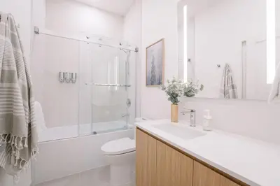 a white bathroom with a sink and a shower at Ridgeline Penthouse by Revelstoke Vacations in Revelstoke