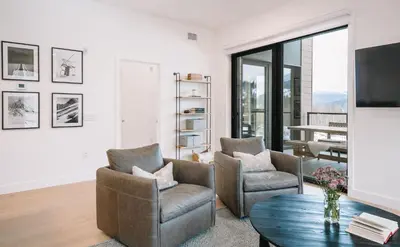 a living room with two chairs and a table at Ridgeline Penthouse by Revelstoke Vacations in Revelstoke