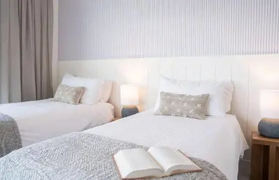 a bedroom with two beds with a book on it at Powder and Par Penthouse by Revelstoke Vacations in Revelstoke
