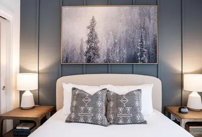 a bedroom with a bed with two lamps and a painting at Powder and Par Penthouse by Revelstoke Vacations in Revelstoke